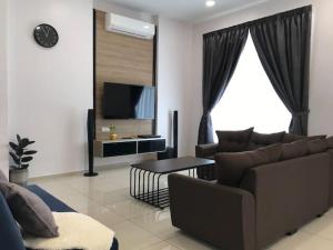 a living room with a couch and a tv at G-Homestay @ Sungai Abong Muar*10~20pax in Muar