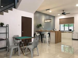 - une cuisine et une salle à manger avec une table et des chaises dans l'établissement G-Homestay @ Sungai Abong Muar*10~20pax, à Muar