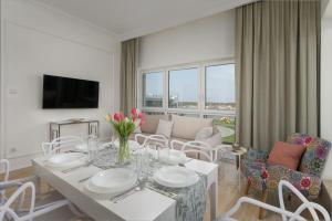 a white dining room with a table and chairs at Apartament Luna Dziwnów in Dziwnów