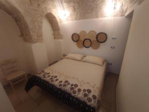 a bedroom with a bed and two mirrors on the wall at Trullo Civico 25, Cummersa Civico 23 in Alberobello