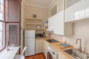 une cuisine avec un réfrigérateur blanc et un évier dans l'établissement Apartamento Boutique frente a la Playa, à Santa Cruz de la Palma