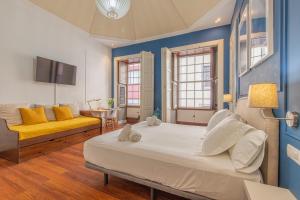 - une chambre avec un grand lit et un canapé jaune dans l'établissement Apartamento Boutique frente a la Playa, à Santa Cruz de la Palma