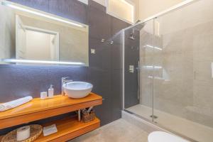 une salle de bain avec un lavabo et une douche en verre dans l'établissement Apartamento Boutique frente a la Playa, à Santa Cruz de la Palma 21 autres photos
