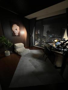 um quarto escuro com uma secretária e uma cadeira num quarto em Somihome em Ho Chi Minh