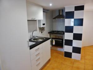 a small kitchen with a sink and a stove at Apartamento Embaixador Mateus in Lisbon