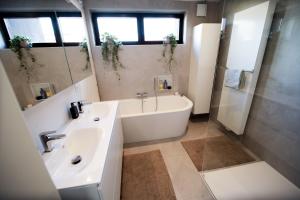 y baño con lavamanos, bañera y lavamanos. en Privé kamer met chill room en gedeelde badkamer - rand Antwerpen - afrit E313 Wommelgem - vlakbij tramhalte lijn 9 en 24, en Amberes