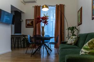 a living room with a table and a green couch at La Premiere Suite - Teatro Massimo Palermo in Palermo