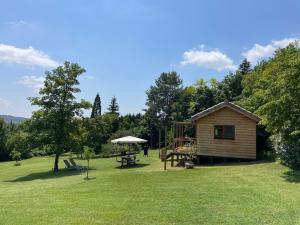 a small cabin with a picnic table and a playground at Mas des Poutres - Tiny house in Charmes-sur-lʼHerbasse