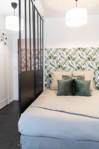 een slaapkamer met een groot bed met groene kussens bij Le charmant Yin-Yang studio proche de Paris in Montrouge