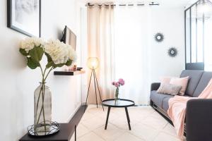 un soggiorno con un vaso di fiori su un tavolo di Le charmant Yin-Yang studio proche de Paris a Montrouge