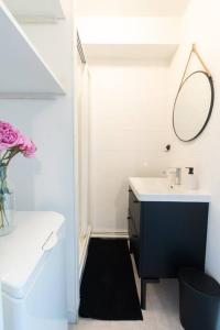 een badkamer met een wastafel en een spiegel bij Le charmant Yin-Yang studio proche de Paris in Montrouge