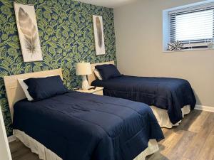 two beds in a room with blue sheets and green wallpaper at 2 Bed 2 Bath Beach Front Condo with Fantastic Amenities at Myrtle Beach Resort in Myrtle Beach