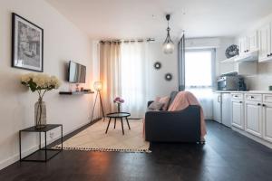 een woonkamer met een bank en een tafel bij Le charmant Yin-Yang studio proche de Paris in Montrouge