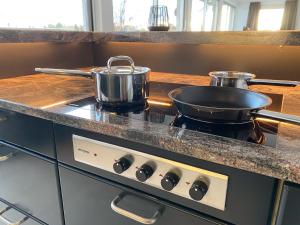 a stove with two pots and pans on it in a kitchen at Exklusives Penthouse 232QM Whirlpool 28min bis Düsseldorf Messe in Mönchengladbach