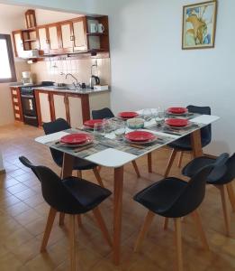 a table with red plates and glasses on it in a kitchen at DEPARTAMENTO RIO TERCERO in Río Tercero