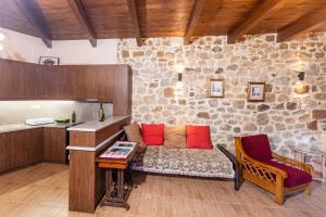 a living room with a couch in a stone wall at Stone House in Astérion