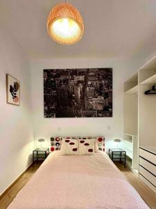 ein Schlafzimmer mit einem großen Bett und einem Gemälde an der Wand in der Unterkunft centro Madrid / chueca (1) in Madrid