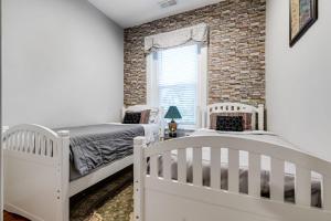 a bedroom with two beds and a brick wall at E2 Centrally located in Carytown fully fenced in Richmond