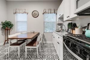 a kitchen with white cabinets and a table with chairs at E2 Centrally located in Carytown fully fenced in Richmond