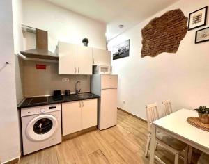 a kitchen with a refrigerator and a washer and a table at centro Madrid / chueca (1) in Madrid