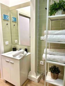 uma casa de banho com lavatório, espelho e toalhas em centro Madrid / chueca (1) em Madri
