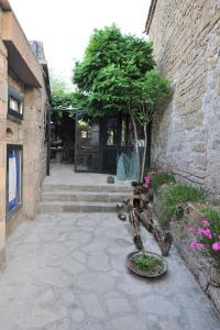 un patio con una estatua frente a un edificio en Assosyal Hotel en Behramkale