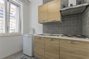 a kitchen with wooden cabinets and a sink and a window at Moca Rooms Onda in Bari +22 photos
