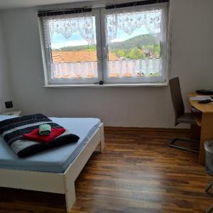 Schlafzimmer mit einem Bett und einem Fenster in der Unterkunft Wilhelm Busch Stube in Ebergötzen