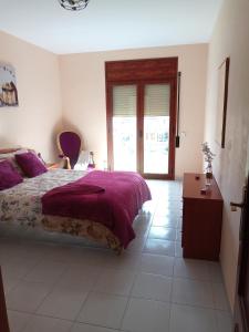 - une chambre avec un lit avec des draps violets et une table dans l'établissement Ebro Escape Luxury Apartment, à Móra d'Ebre