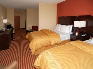 a hotel room with two beds and a desk at Hometown Executive Suites in Bridgeport