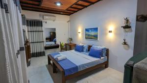 a bedroom with a bed with blue pillows at Jennifer's Villa in Negombo