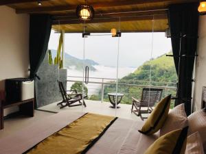 een slaapkamer met een bed en een groot raam bij Ella HIDE VIEW in Ella
