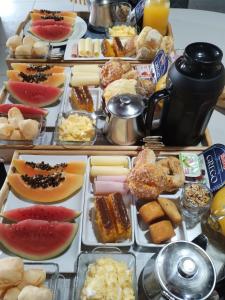 a table filled with different types of food on trays at Suite com piscina in Florianópolis