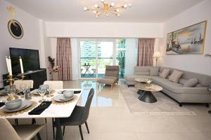 sala de estar con sofá y mesa con sillas en Mariana Luxurious 2BR Apartment, en Abu Dabi