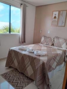 een slaapkamer met een bed met twee handdoeken erop bij Pousada La Belle in Maragogi
