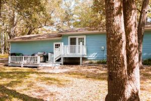 a blue house with a porch and a deck at Town & Country Hideaway - 1BR/1BA, 20 min FAMU/FSU in Tallahassee