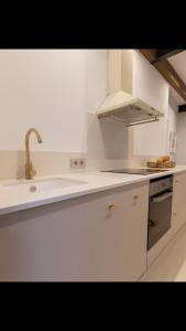 a white kitchen with a sink and a stove at MEDITERRÀNIA RURAL in Cabanes