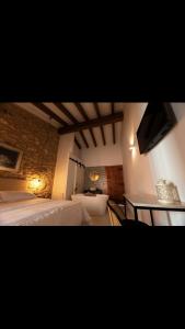 a bedroom with a bed and a desk and a television at MEDITERRÀNIA RURAL in Cabanes