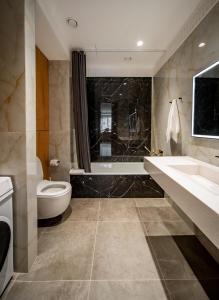 ein Badezimmer mit einem WC, einem Waschbecken und einer Badewanne in der Unterkunft Deluxe Apartment in Taschkent