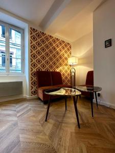 een woonkamer met een bank en 2 tafels bij Seventies, vintage et bohème in Bourgoin
