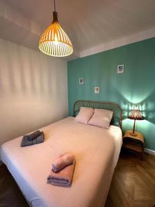 1 dormitorio con 1 cama grande y 2 toallas. en Seventies, vintage et bohème, en Bourgoin