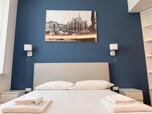ein blaues Schlafzimmer mit einem Bett mit zwei Handtüchern darauf in der Unterkunft Spazio Stoppani - Liberty 28 in Mailand