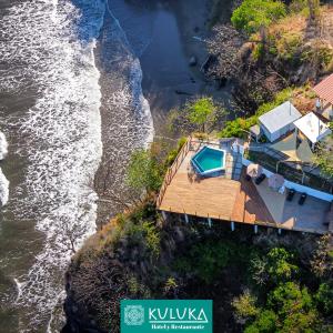 an aerial view of a house on a cliff next to the water at Kuluka Resort And Spa in San Miguel