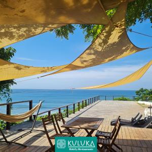 a table and chairs on a deck with a view of the ocean at Kuluka Resort And Spa in San Miguel