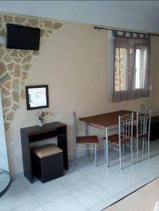 a dining room with a table and chairs and a television at Apartments Anyfantis in Stómion