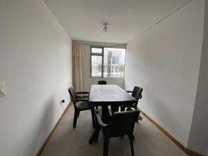 - une table et des chaises dans une chambre avec fenêtre dans l'établissement Apartamento Belen, à Manizales