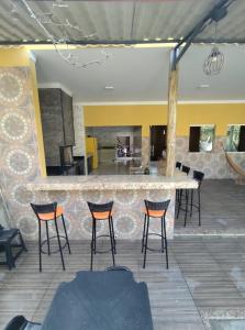 - un bar avec des chaises et un comptoir dans une pièce dans l'établissement Casa caju, à Santa Cruz Cabrália