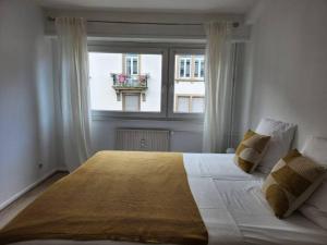 een slaapkamer met een groot bed en een raam bij Logement familial/ Orangerie in Straatsburg