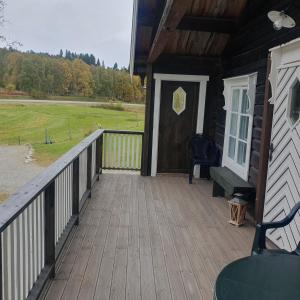 een veranda van een hut met een deur en een veld bij Brekkveien 81-meget sentral hytte,15 min å gå til Røros sentrum in Røros