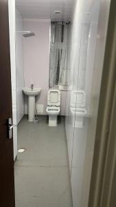 baño con 2 aseos y lavamanos en Large 3 Bed Apt close to city, OVO Hydro and Ibrox Stadium en Glasgow